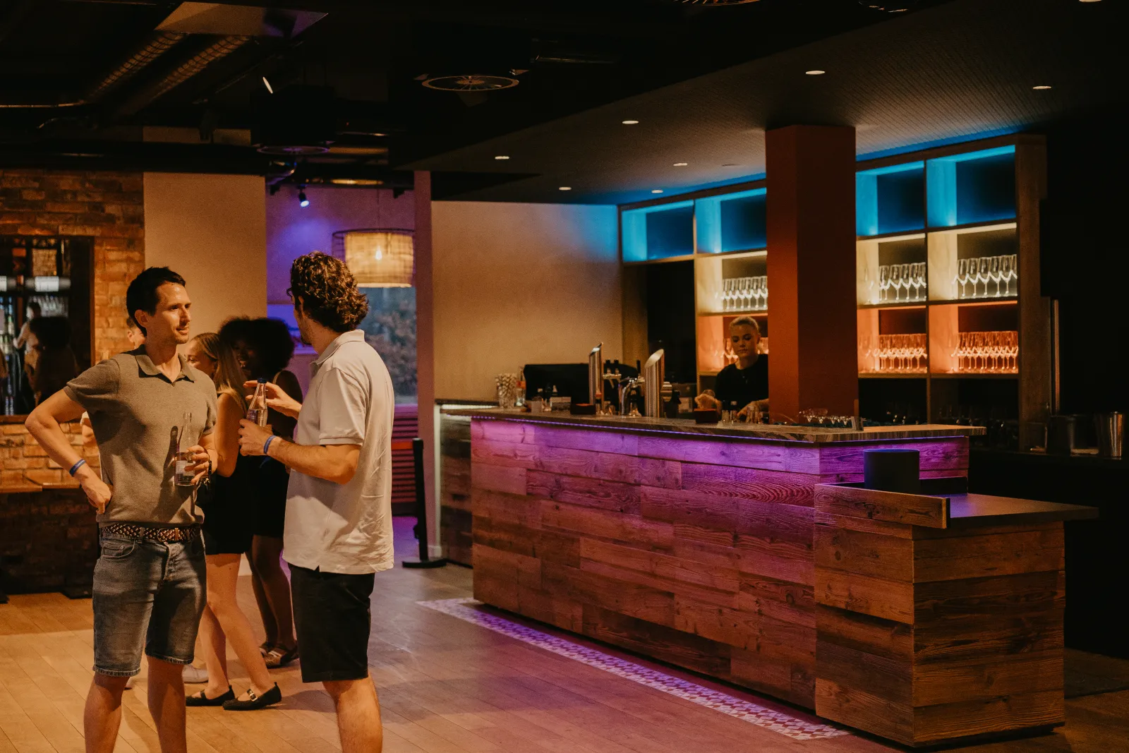 Gäste an der Bar im Innenraum am Abend